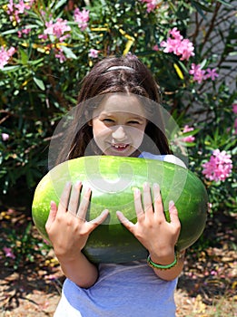 Smiling little girl with an enormous WATERMELON