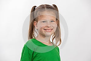 Smiling little girl in green t-shirt over white background