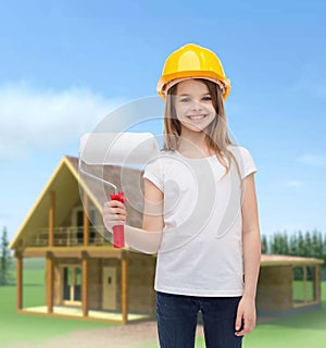 Smiling little girl in helmet with paint roller