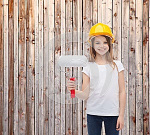 Smiling little girl in helmet with paint roller