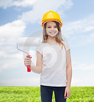 Smiling little girl in helmet with paint roller