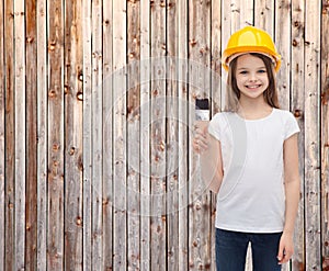 Smiling little girl in helmet with paint roller