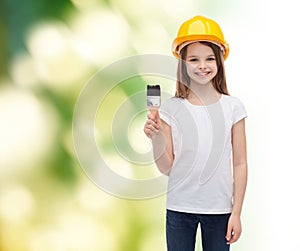 Smiling little girl in helmet with paint roller