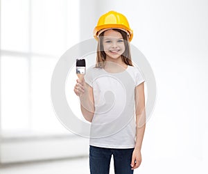 Smiling little girl in helmet with paint roller