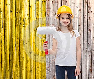 Smiling little girl in helmet with paint roller