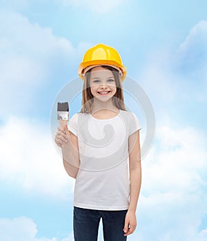 Smiling little girl in helmet with paint roller