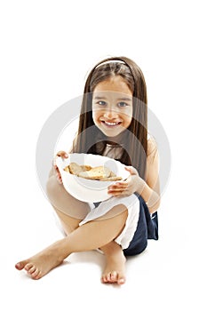 Smiling little girl holding a bowl with cookie or biscuit