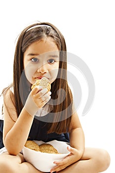 Smiling little girl holding a bowl with cookie or biscuit
