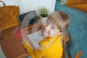 Smiling little girl at home. Distance learning, hobby and leisure activity concept