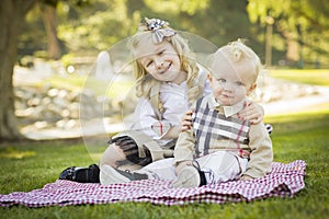 Smiling Little Girl Hugs Her Baby Brother at the Park