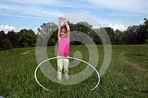 Smiling Little Girl With Hula Hoop Enjoying Beautiful Spring Day In The Park