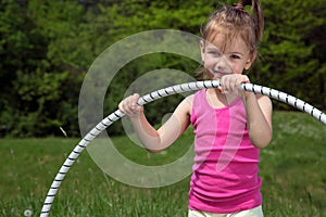 Smiling Little Girl With Hula Hoop Enjoying Beautiful Spring Day In The Park