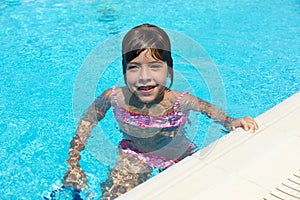 Smiling little girl looking at camera in an outdoor pool