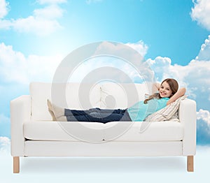 Smiling little girl lying on sofa