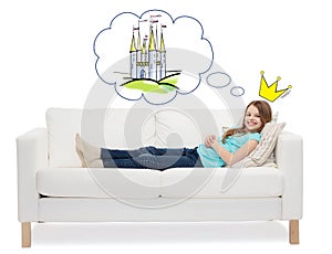 Smiling little girl lying on sofa and dreaming