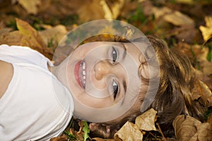 Smiling little girl playing in Autumn