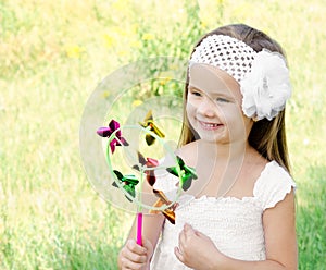 Smiling little girl playing with windmill toy