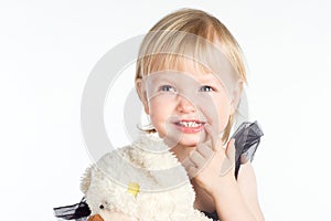 Smiling little girl pointing at her healthy white teeth