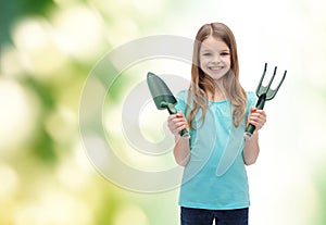 Smiling little girl with rake and scoop