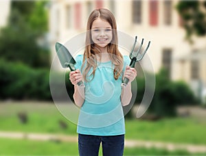 Smiling little girl with rake and scoop