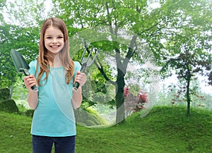 Smiling little girl with rake and scoop