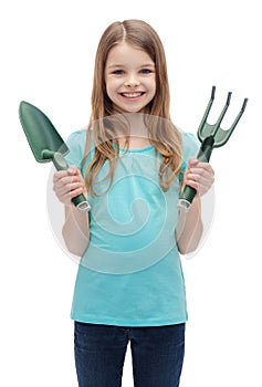 Smiling little girl with rake and scoop