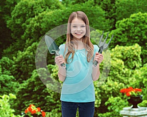 Smiling little girl with rake and scoop