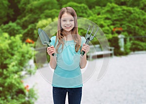 Smiling little girl with rake and scoop