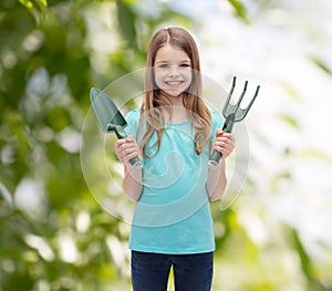 Smiling little girl with rake and scoop