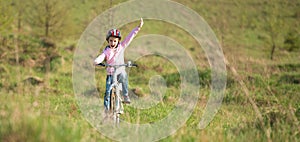 Smiling little girl riding a bike