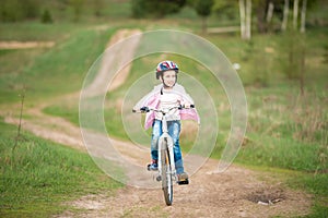 Smiling little girl riding a bike