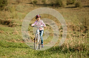 Smiling little girl riding a bike