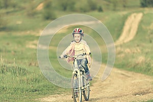 Smiling little girl riding a bike