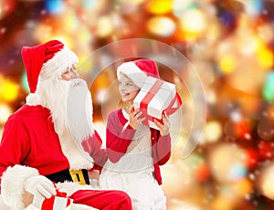 Smiling little girl with santa claus and gifts