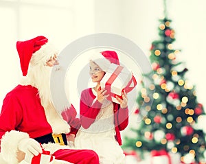 Smiling little girl with santa claus and gifts