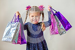 Smiling little girl with shopping bags. Black Friday sale