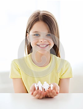 Smiling little girl showing paper man family