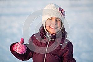 Smiling little girl skating at the rink in winter