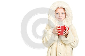 Smiling little girl in winter clothes with a red cup of hot drink