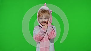 Little kid girl daughter in unicorn pajamas using speaking talking on mobile cell phone with mother