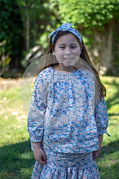 Smiling little latina girl in garden in Spring dress