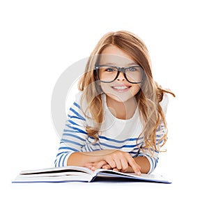 Smiling little student girl lying on the floor