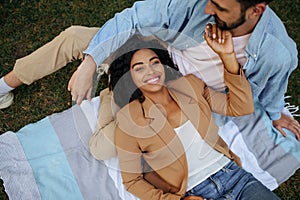 Smiling love couple resting on the grass, top view