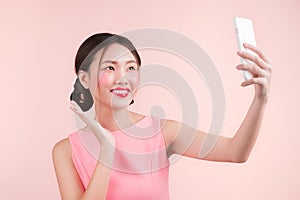 Smiling lovely active asian girl taking selfie photo.