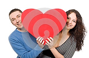 Smiling loving couple holding heart