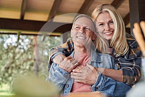 Smiling loving elderly couple spending time in open terrace