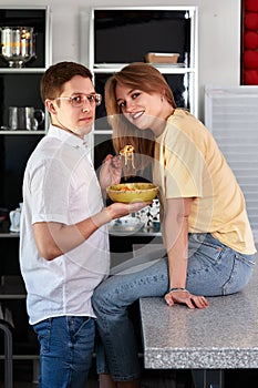 Smiling loving husband feeding wife, young couple enjoying tender moment, romantic date, having fun, eating japanese