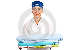 Smiling maid holding stack of bed sheet