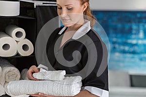 Smiling maidservant with white towels photo