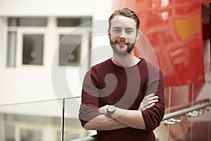 Smiling male adult student in modern university building